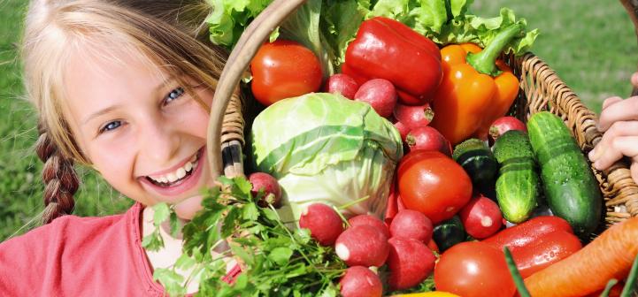 Smiling girl with basket of vegetables