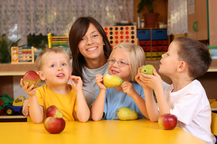 teacher and children eating fruit 
